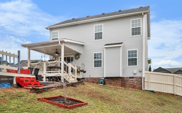 rear view of property with ceiling fan, a yard, and a wooden deck