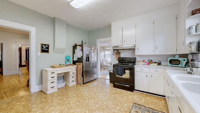 kitchen with sink, white cabinetry, stainless steel fridge, and black electric range oven