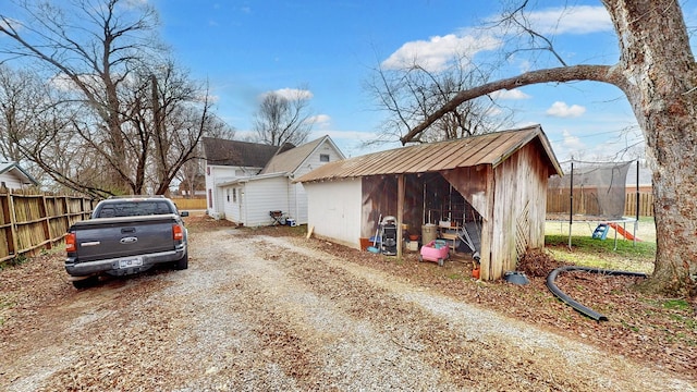 view of side of home with an outbuilding and a trampoline