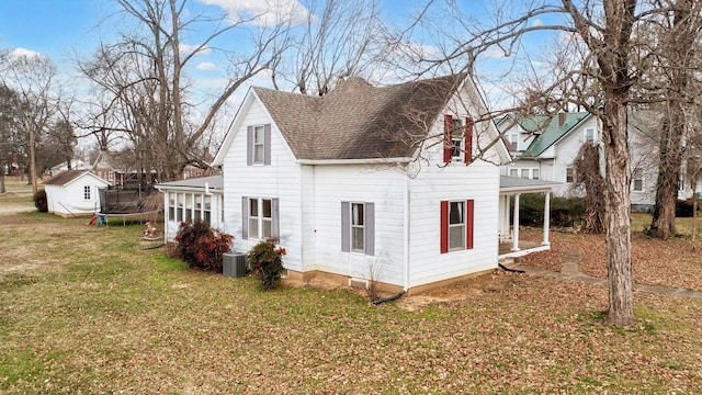 view of side of home with cooling unit and a lawn