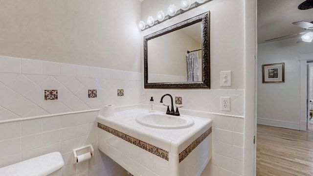 bathroom featuring wood-type flooring, sink, and tile walls