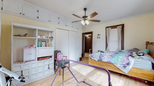 bedroom with ceiling fan, ornamental molding, a closet, and light wood-style floors