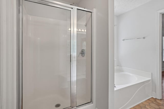 bathroom with a textured ceiling, tile patterned flooring, and shower with separate bathtub