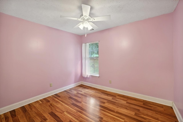 unfurnished room with ceiling fan, wood-type flooring, and a textured ceiling