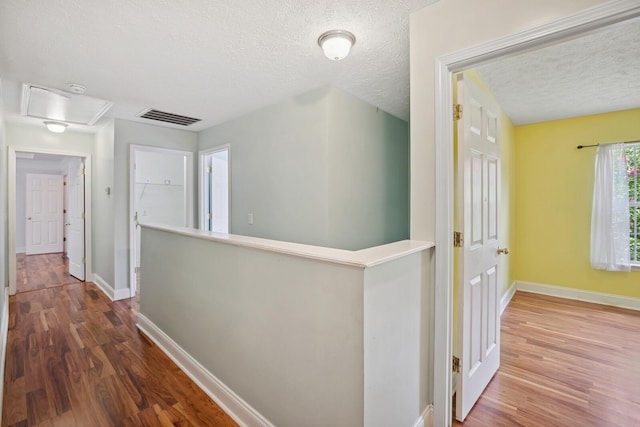 hall featuring hardwood / wood-style floors and a textured ceiling