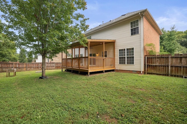 back of property with a deck and a yard