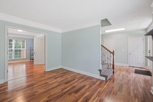 spare room with hardwood / wood-style flooring, crown molding, and a textured ceiling