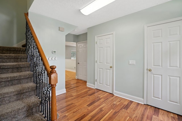 stairway featuring wood-type flooring and a textured ceiling