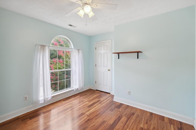 empty room featuring ceiling fan, a textured ceiling, and light wood-type flooring