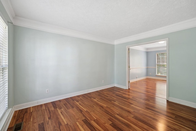 empty room with crown molding, a healthy amount of sunlight, hardwood / wood-style flooring, and a textured ceiling