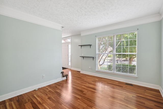 unfurnished room featuring crown molding, hardwood / wood-style flooring, and a textured ceiling