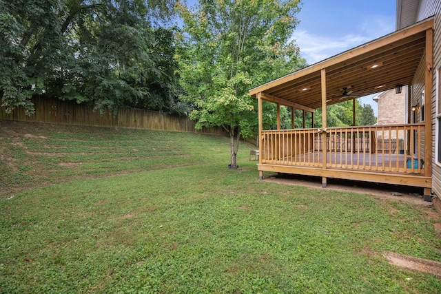 view of yard featuring a wooden deck and ceiling fan