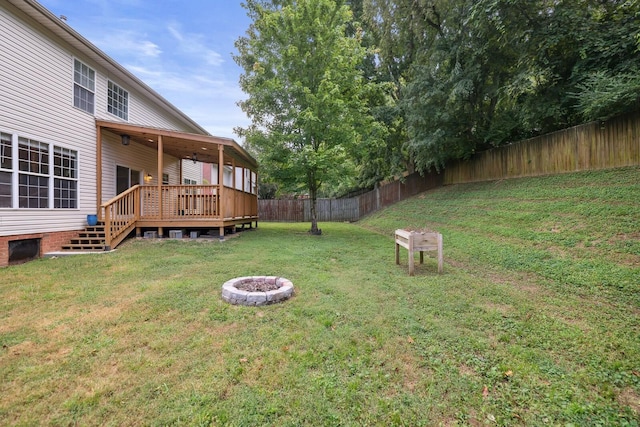 view of yard featuring a deck and an outdoor fire pit