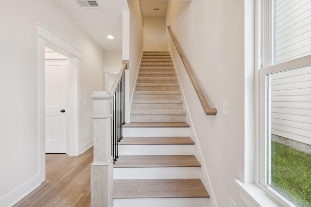 stairs featuring hardwood / wood-style floors