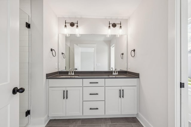 bathroom with a shower with door, vanity, and tile patterned flooring