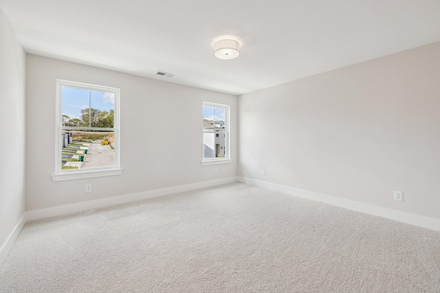 carpeted spare room featuring a wealth of natural light