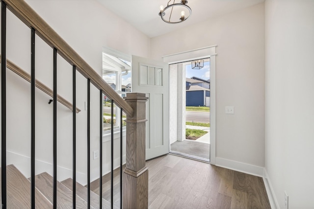 foyer entrance with wood-type flooring and a notable chandelier