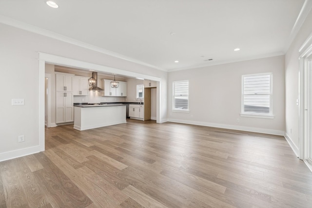 unfurnished living room featuring light wood-type flooring and crown molding