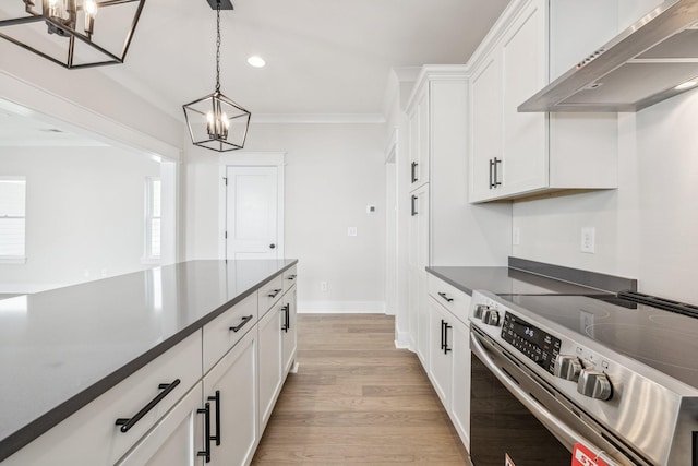 kitchen with wall chimney exhaust hood, stainless steel electric stove, white cabinetry, and hanging light fixtures