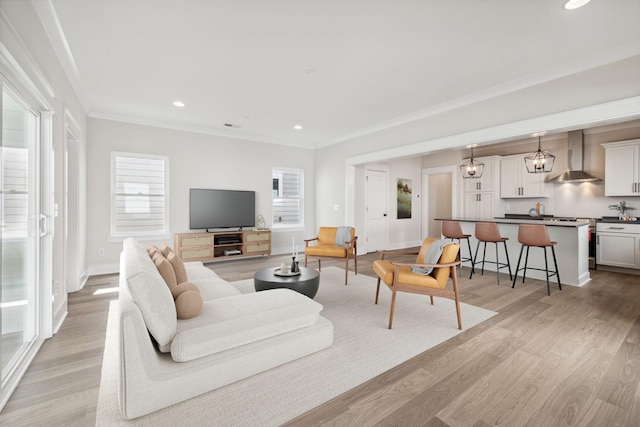 living room with light hardwood / wood-style flooring and ornamental molding