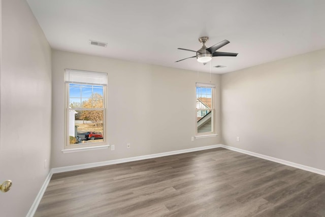 empty room with dark wood-type flooring and ceiling fan