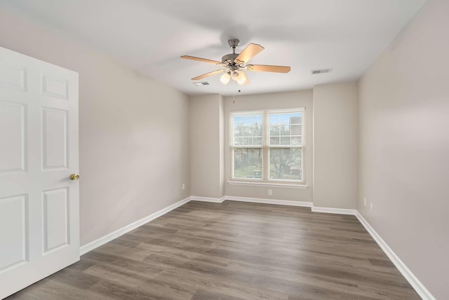 unfurnished room with ceiling fan and dark wood-type flooring