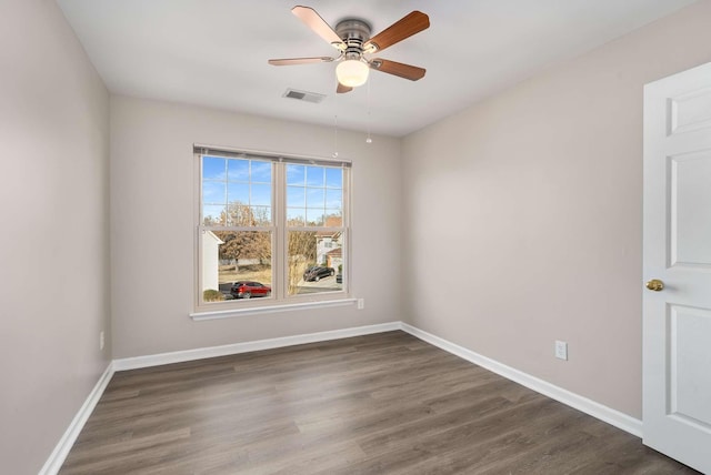 spare room with ceiling fan and dark hardwood / wood-style flooring