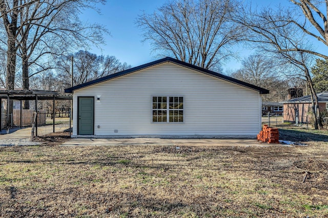 back of property featuring an outbuilding and a yard