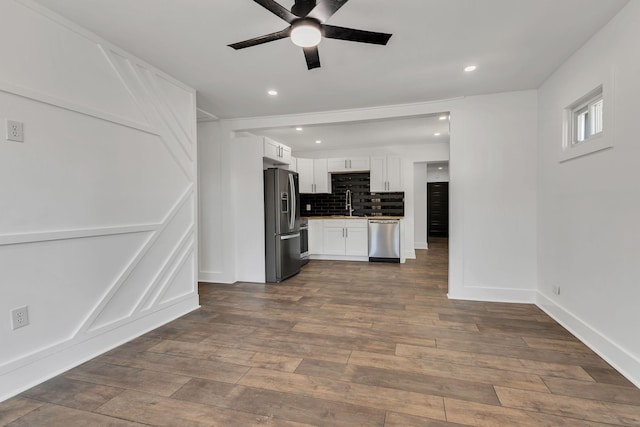 kitchen featuring ceiling fan, appliances with stainless steel finishes, sink, backsplash, and white cabinets