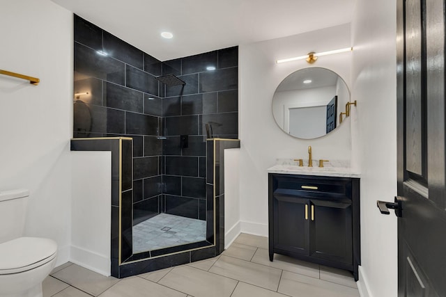 bathroom featuring vanity, toilet, tile patterned floors, and a tile shower