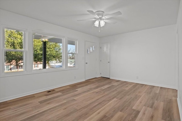 spare room featuring ceiling fan, light hardwood / wood-style floors, and plenty of natural light