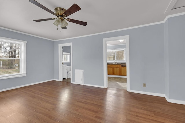 empty room with crown molding, dark wood-type flooring, and a wealth of natural light