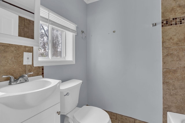 bathroom with vanity, toilet, and a bathing tub