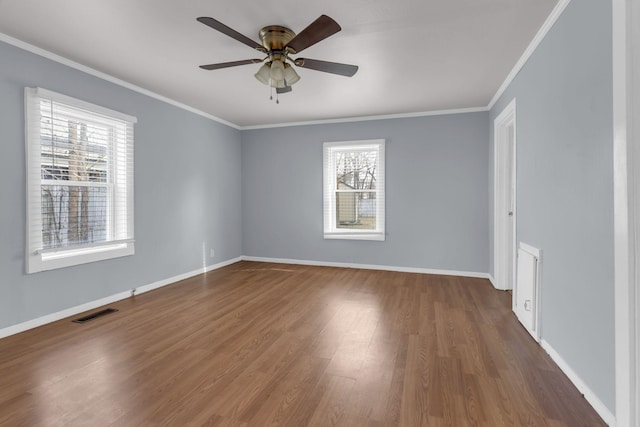 spare room featuring ceiling fan, ornamental molding, plenty of natural light, and dark hardwood / wood-style flooring