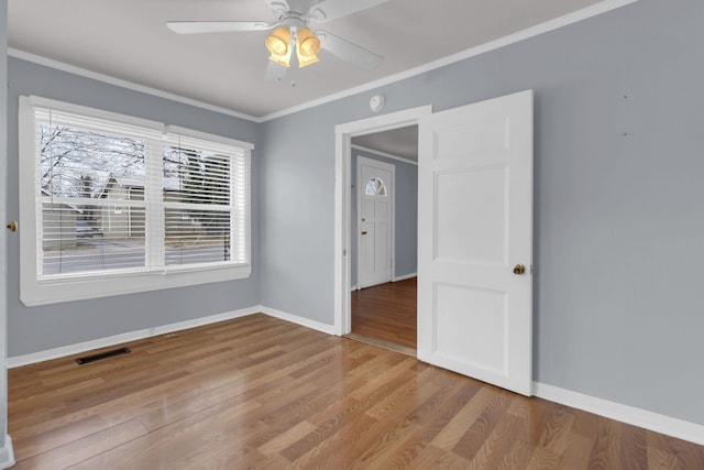 empty room with light hardwood / wood-style flooring, ceiling fan, and ornamental molding