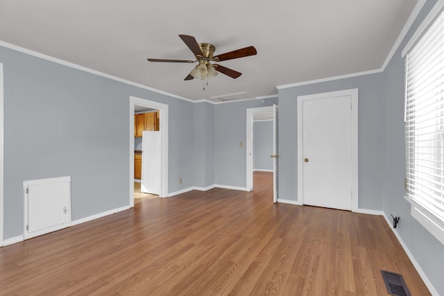 spare room with crown molding, light hardwood / wood-style floors, and ceiling fan