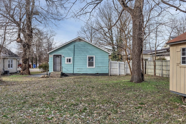 rear view of house with cooling unit and a yard