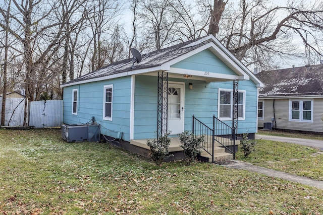 bungalow-style home with a front yard and central AC unit