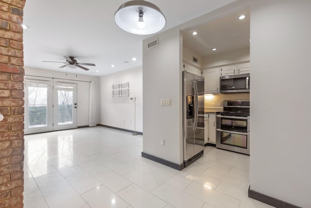 kitchen with ceiling fan, tasteful backsplash, white cabinetry, light tile patterned floors, and stainless steel appliances