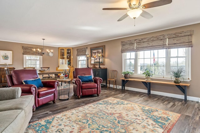 living room featuring ceiling fan with notable chandelier, dark hardwood / wood-style flooring, and crown molding