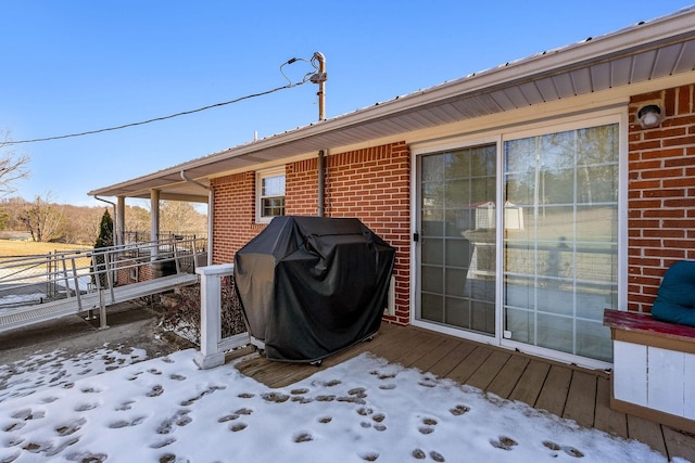 snow covered deck with a grill