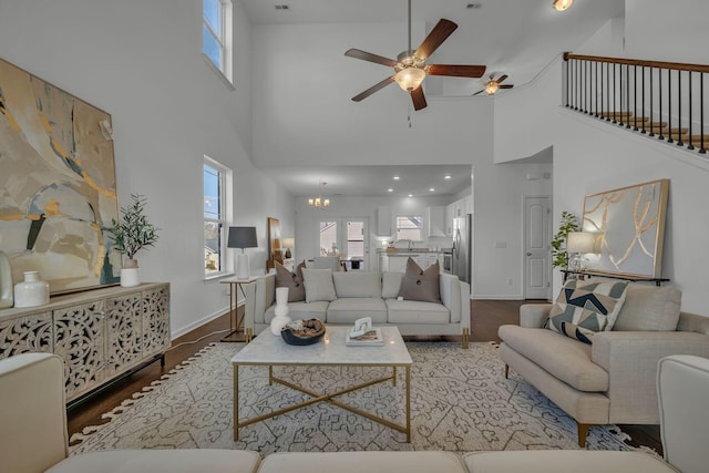 living room with a towering ceiling, a wealth of natural light, and hardwood / wood-style floors