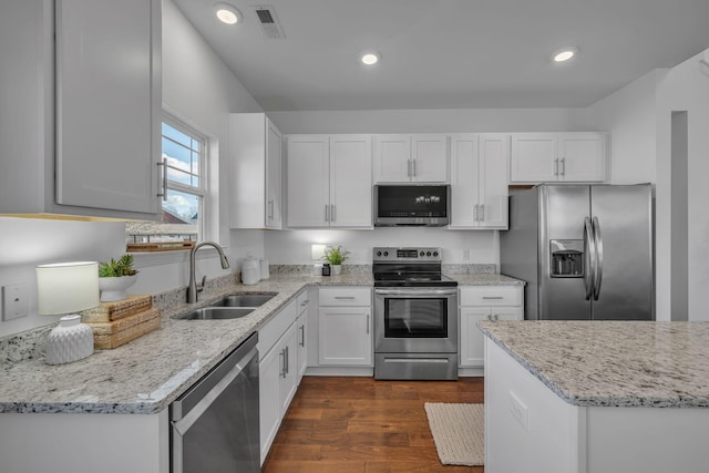 kitchen featuring white cabinets, appliances with stainless steel finishes, dark hardwood / wood-style flooring, sink, and light stone counters