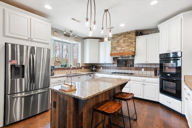 kitchen featuring stainless steel appliances, a center island, sink, and white cabinets