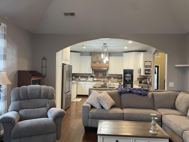 living room with lofted ceiling, sink, and dark wood-type flooring