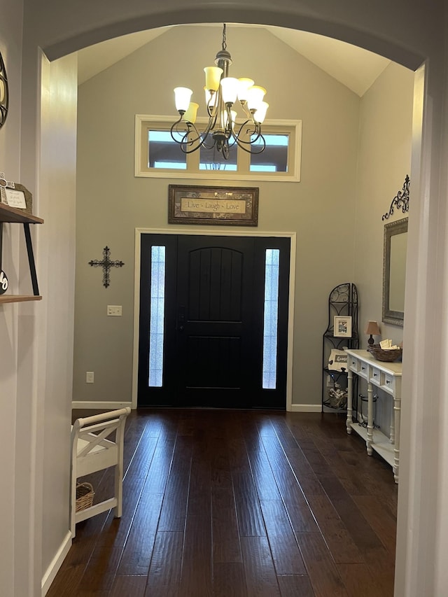 foyer featuring a notable chandelier, dark wood-type flooring, and high vaulted ceiling