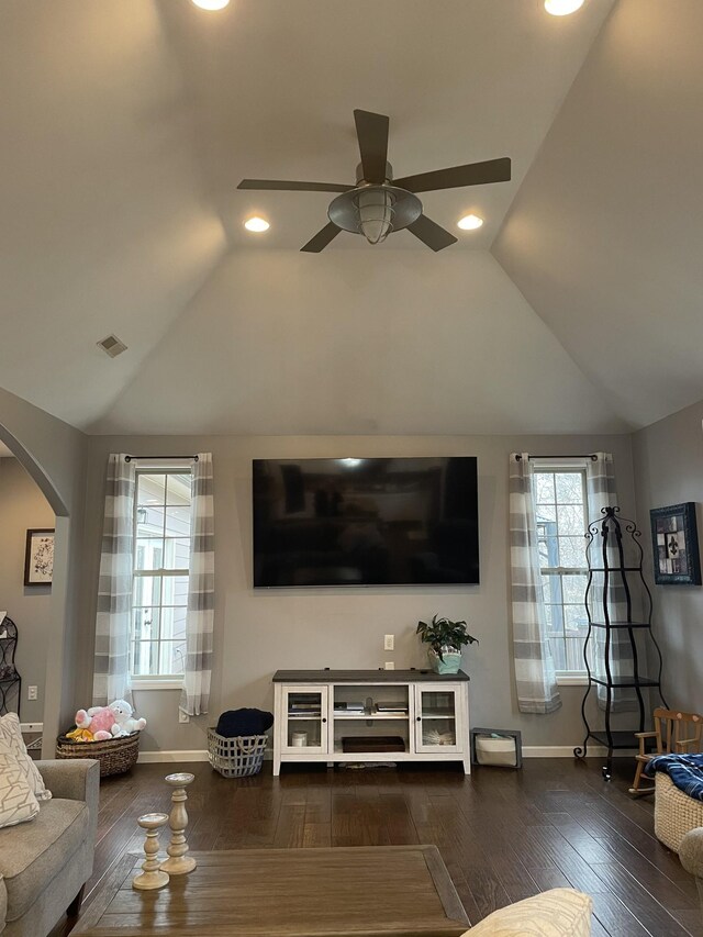 living room with lofted ceiling, dark wood-type flooring, ceiling fan, and plenty of natural light