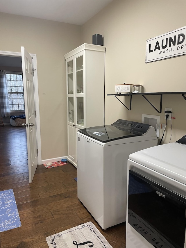 laundry area with cabinets, washing machine and clothes dryer, and dark hardwood / wood-style flooring