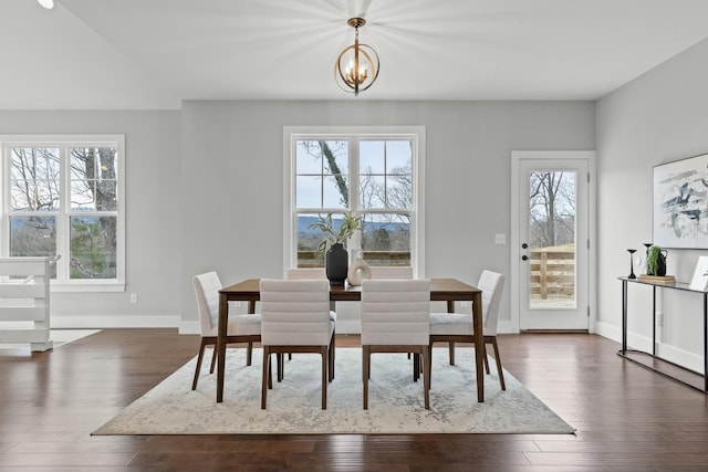 dining room with dark hardwood / wood-style floors and a notable chandelier