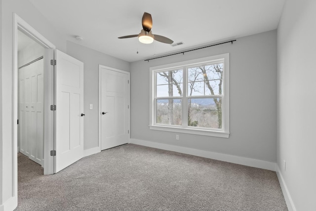 unfurnished bedroom featuring ceiling fan and light carpet